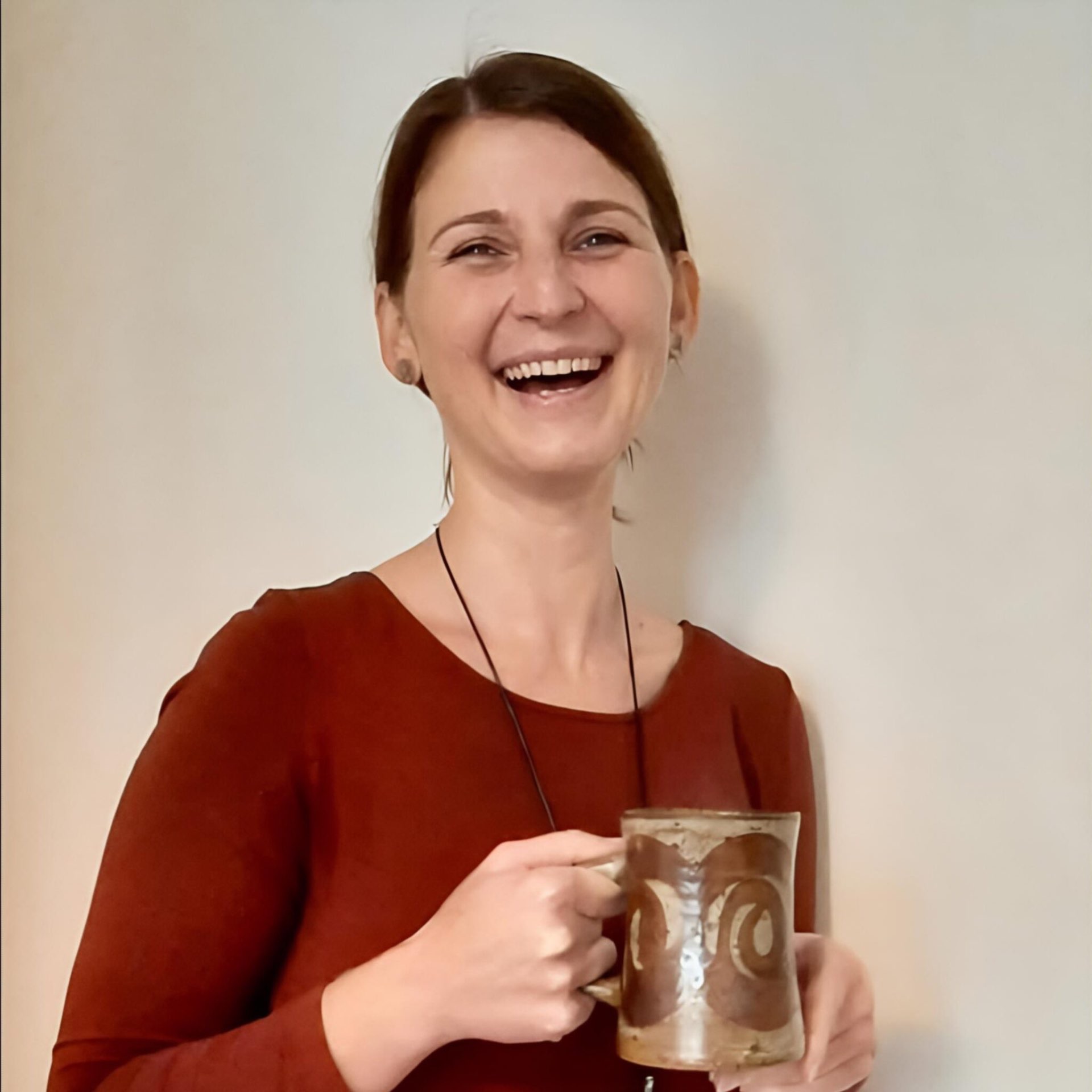 Katarzyna Jurewicz – psychotraumatolog, uśmiechnięta kobieta z kubkiem